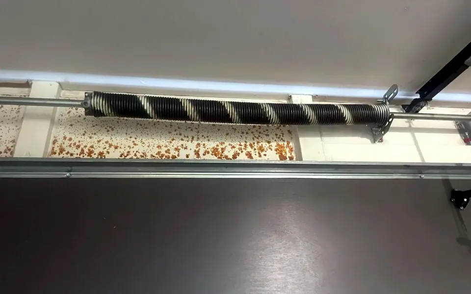 Torsion spring and shaft above a sectional garage door